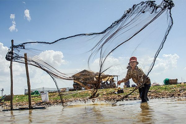 Cast fishing net on Tonle Sap Lake - 25 Days in Indochina