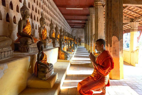 A Laos monk are praying in Wat Si Saket