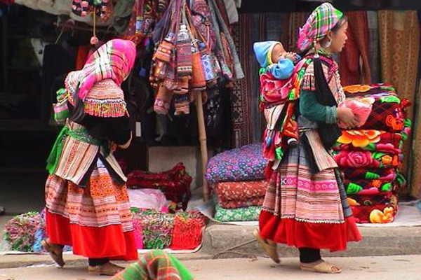 H'mong mothers piggyback their children on the way to Cao Son market