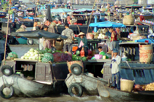 In the early morning rafts and boats are crowded in Cai Be Floating market