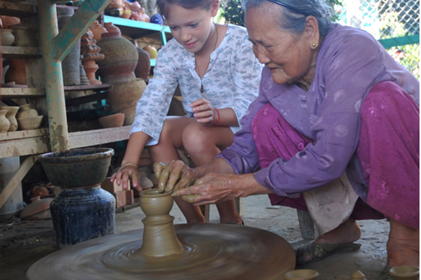 Pottery artisans of Thanh Ha village guide the visiotors to make ceramic products