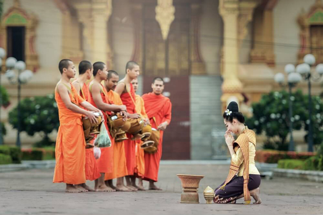 Laos woman offering food for monk and show her respect